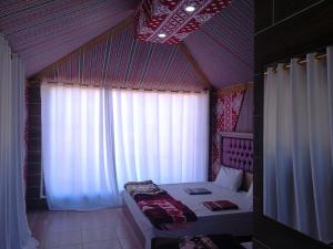a small bedroom with a bed and a window at WADI RUM STAR WARS CAMP in Wadi Rum +69 photos