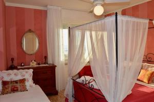 una camera con letto a baldacchino e specchio di Appartamento Deluxe Frontemare a Camaiore