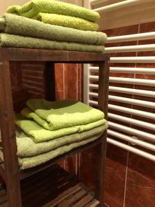 una pila de toallas verdes en una estantería de madera en Nina Apartment, en Wiener Neustadt