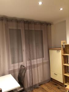 Zimmer mit zwei Fenstern mit Vorhängen und einem Regal in der Unterkunft Nina Apartment in Wiener Neustadt