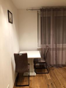 Habitación con mesa blanca y 2 sillas en Nina Apartment, en Wiener Neustadt