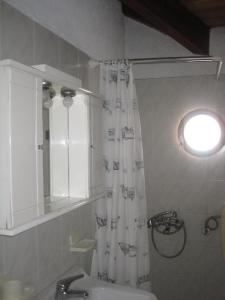y baño con cortina de ducha y lavamanos. en Marina Studios I, en Argostoli