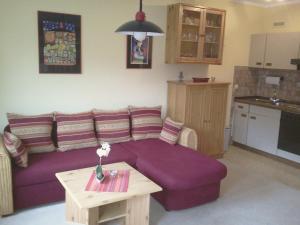 a living room with a purple couch and a table at Appartement Moselblick in Cochem