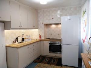 a kitchen with white cabinets and a white refrigerator at Aspa's Traditional House in Plomari