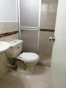 a bathroom with a toilet and a sink and a shower at Aparta Hotel Victoria In in Bogotá