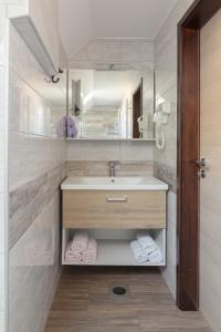 bagno con lavandino, specchio e asciugamani di Apartments Katja a Bohinj