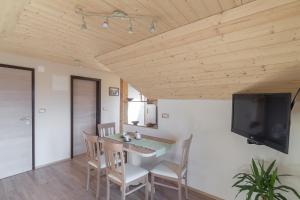 a dining room with a table and chairs and a flat screen tv at Apartments Katja in Bohinj