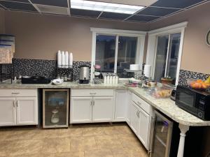 cocina con armarios blancos y encimera en Americas Best Value Inn - Gaylord, en Gaylord