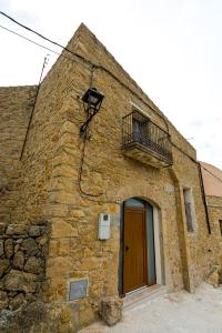 Edificio de piedra con puerta y balcón en Casa Rural La Vinyeta, en Ballestar