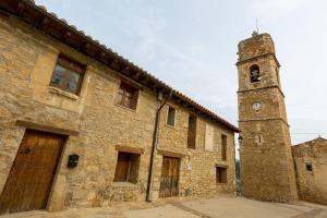 an old stone building with a clock tower at Casa Rural La Vinyeta in Ballestar