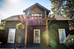 a house with a wooden deck on top of it at Guest suites on Benvenuto in Brentwood Bay