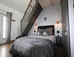 a bedroom with a large bed and a staircase at La Haute Muraille in Saint-Folquin