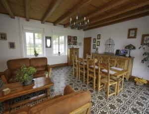 a living room with a couch and a table and chairs at La Haute Muraille in Saint-Folquin