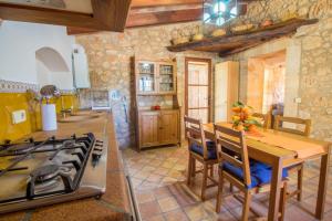 cocina con mesa de madera y fogones horno superior en Preciosa Finca rustica con A/C y piscina exclusiva, en Algaida