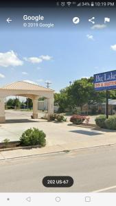 una señal frente a un edificio con una gasolinera en Big Lake Inn and Suites, en Big Lake