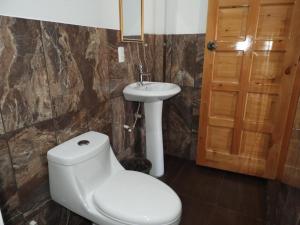 a bathroom with a toilet and a sink at Hotel Adulam in San Pedro La Laguna