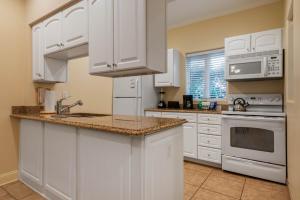 a white kitchen with white cabinets and appliances at Villas Of Amelia Island in Amelia Island