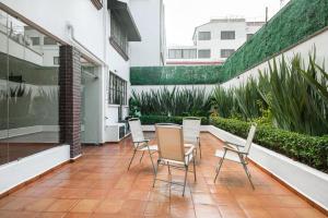 un patio avec des chaises et une table dans un bâtiment dans l'établissement Finca Coyoacán, à Mexico