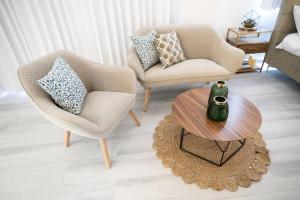 ein Wohnzimmer mit 2 Stühlen und einem Tisch in der Unterkunft צימר בוטיק אדלה Zimmer boutique adela in Arad