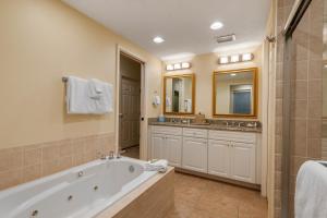 a bathroom with a tub and two sinks and a shower at Villas Of Amelia Island in Amelia Island