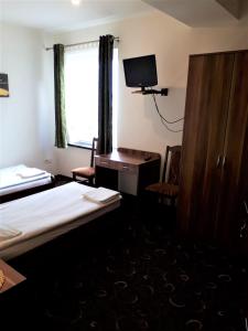a hotel room with two beds and a television at Motel Orion Wolsztyn in Wolsztyn