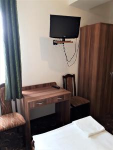 a room with a desk and a tv on the wall at Motel Orion Wolsztyn in Wolsztyn