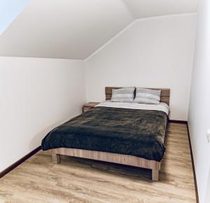 a bedroom with a bed and a wooden floor at Kaunas Castle Apartments - 2 Bedroom Flat in Kaunas
