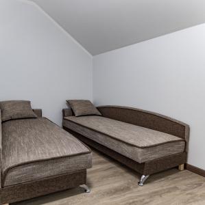 - une chambre avec 2 lits et un pouf dans l'établissement Kaunas Castle Apartments - 2 Bedroom Flat, à Kaunas
