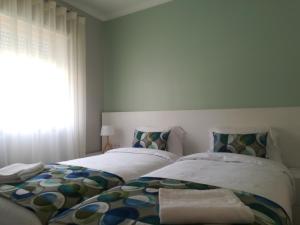 Un dormitorio con dos camas y una ventana. en Praia Del Rey Pool View ByThe Sea, en Casal da Lagoa Seca 15 fotos más