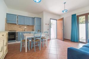 a kitchen with blue cabinets and a table and chairs at Holiday home in Cala Gonone 34367 in Cala Gonone