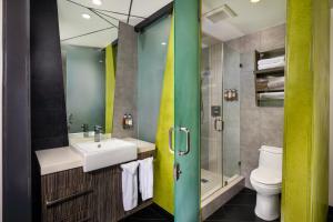 a bathroom with a sink, toilet and shower at The Moment Hotel in Los Angeles