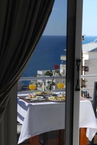 a table with two glasses and a vase with a flower at Villa Doka in Sarandë