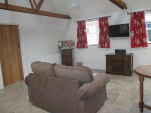 ein Wohnzimmer mit einem Sofa und einem Tisch in der Unterkunft Lavender Cottage in Holmesfield