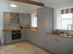 a kitchen with gray cabinets and a sink at Lavender Cottage in Holmesfield