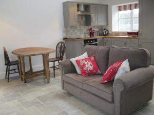 a living room with a couch and a table at Lavender Cottage in Holmesfield