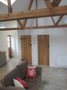 ein Wohnzimmer mit braunem Sofa und Holzdecken in der Unterkunft Lavender Cottage in Holmesfield + 2 Fotos