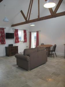 ein Wohnzimmer mit einem Sofa und einem Tisch in der Unterkunft Lavender Cottage in Holmesfield