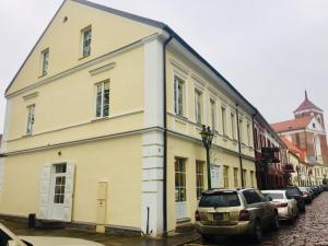 a white building on a street with parked cars at Kaunas Castle Apartments - 2 Bedroom Flat in Kaunas