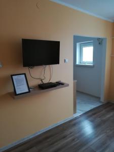 a room with a flat screen tv on a wall at Apartament Reymonta in Łowicz