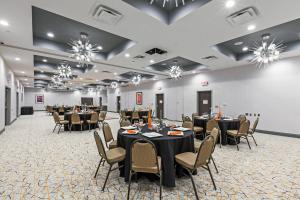 un salón de banquetes con mesas, sillas y lámparas de araña en Holiday Inn Houston NE-Bush Airport Area, an IHG Hotel, en Humble