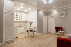 uma cozinha e sala de estar com mesa e cadeiras em VIP- Elite Lemberg Apartments em Lviv
