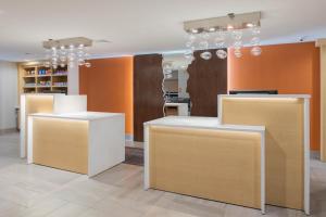a store with white counters and orange walls and chandeliers at La Quinta by Wyndham Perry in Perry +61 photos