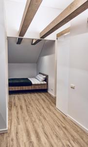 a bedroom with a bed in a room with wood floors at Kaunas Castle Apartments - Studio in Kaunas