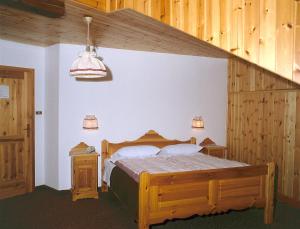 a bedroom with a wooden bed and a staircase at Hotel Pausa in Montagna