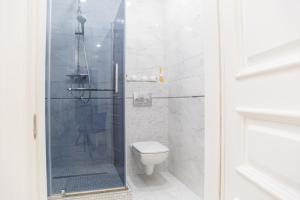 a bathroom with a toilet and a glass shower at VIP- Elite Lemberg Apartments in Lviv