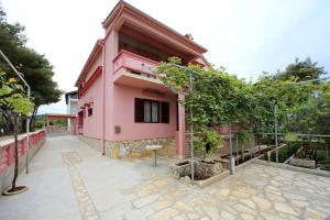 比比涅的住宿－Apartmani Jagoda，粉红色的房子,前面有一个庭院