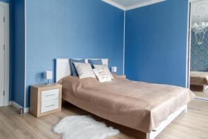 1 dormitorio con cama y pared azul en VIP- Elite Lemberg Apartments en Leópolis