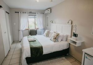 ein Schlafzimmer mit einem großen weißen Bett und einem Fenster in der Unterkunft Sylvern Bed and Breakfast in Durban