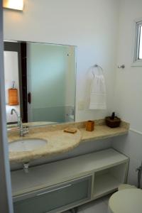 Residência Colibri apto 07 في بورتو سيغورو: حمام مع حوض ومرآة