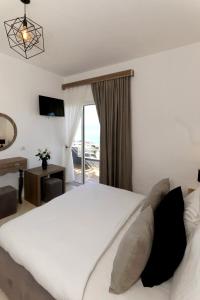Un dormitorio con una gran cama blanca y una ventana en Villa Doka, en Sarandë